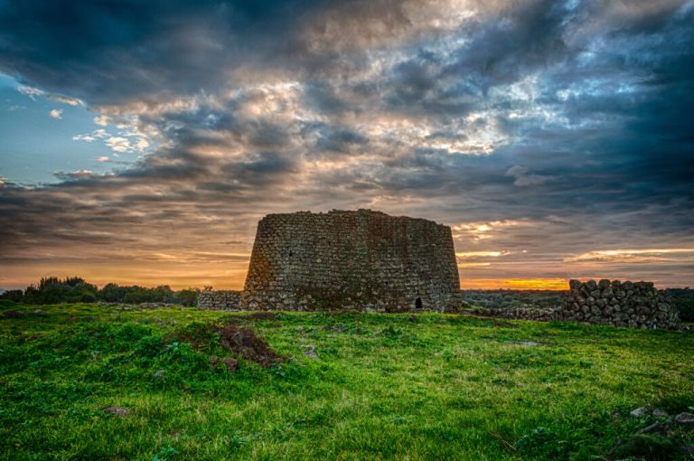 Imponente Nuraghe Su Nuraxi di Barumini in una giornata di sole, con il paesaggio sardo circostante, simbolo della civiltà nuragica.
