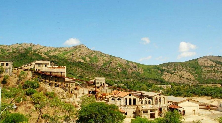 Rovine della miniera di Montevecchio in Sardegna, edifici minerari abbandonati in un paesaggio selvaggio.