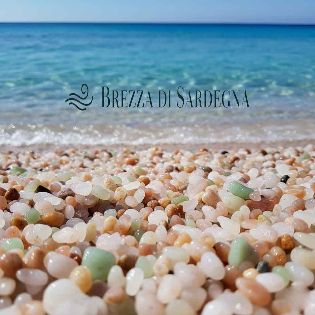 Primo piano della spiaggia is Arutas con i caratteristici chicchi di quarzo colorati e il mare turchese intenso sullo sfondo nella Penisola del Sinis.