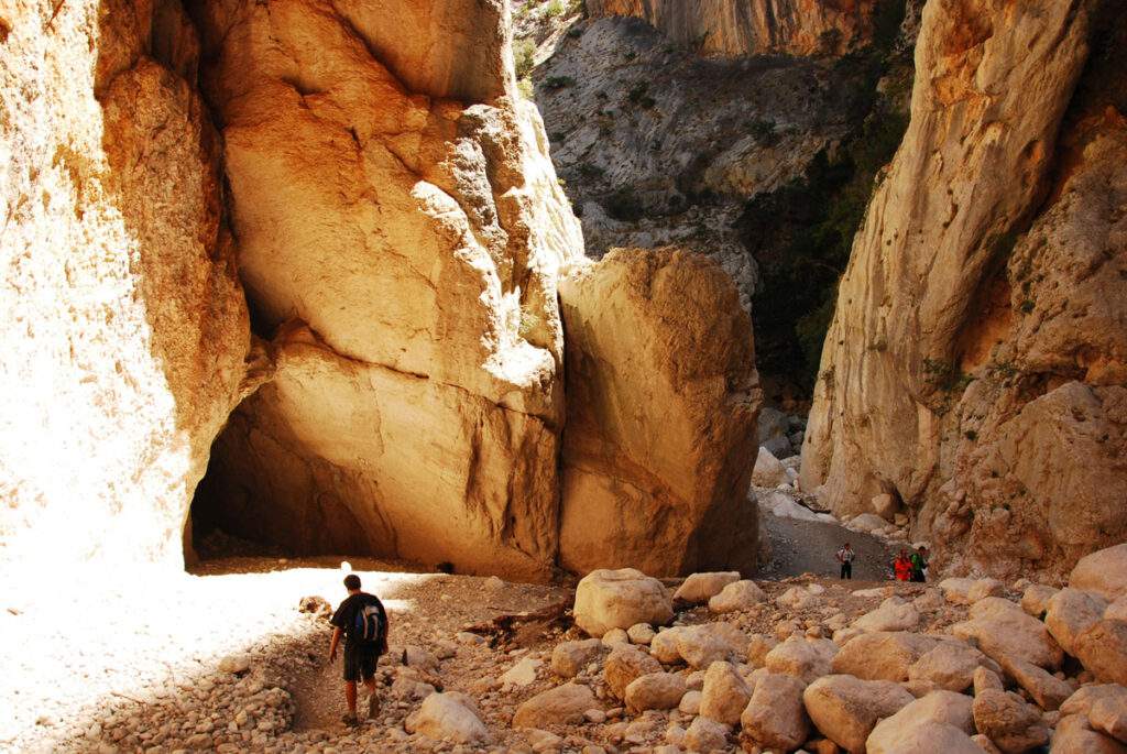 "Escursionista all'interno della Gola di Gorropu, canyon profondo con pareti rocciose, Supramonte Sardegna.